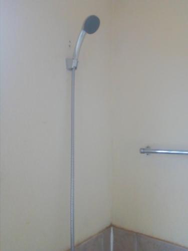 a shower with a shower head in a bathroom at 33 On Swallows Guest House in Soshanguve