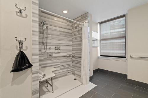 a bathroom with a walk in shower and a sink at Hotel De Anza in San Jose