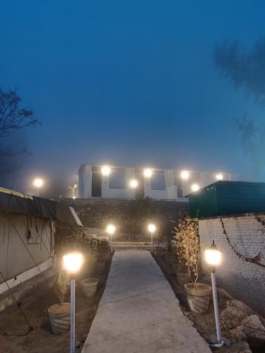 a pathway with lights in front of a building at night at The Sweven NeerVan in Rishīkesh