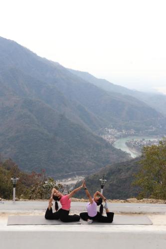 a group of three women doing yoga on top of a mountain at The Sweven NeerVan in Rishīkesh