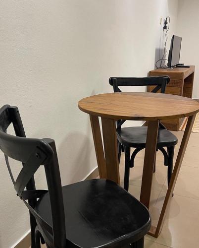 a wooden table and two chairs and a wooden table and chair at Pousada Villa Tiradentes Suítes - Centro in Tiradentes