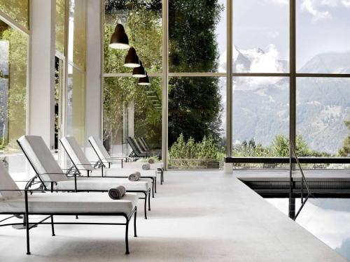 a row of chairs in a room with large windows at Beausite Park Hotel & Spa in Wengen