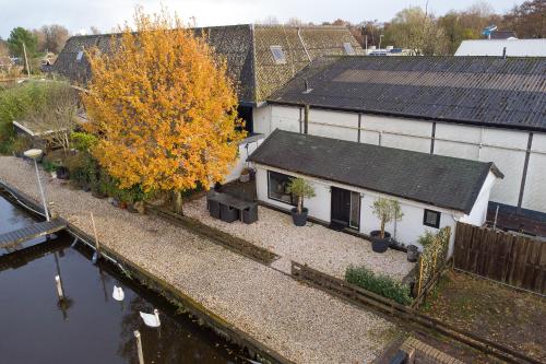an aerial view of a house with a tree and water at Woonboot De Rietpieper in Loosdrecht