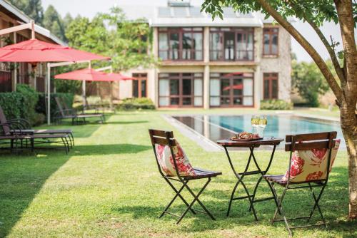 a table and chairs in the grass near a pool at Casterbridge Hollow Boutique Hotel in White River