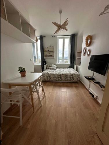 Cette chambre comprend une table et un lit. dans l'établissement Élégance au Bord de l'Eau, à Aiguebelette-le-Lac