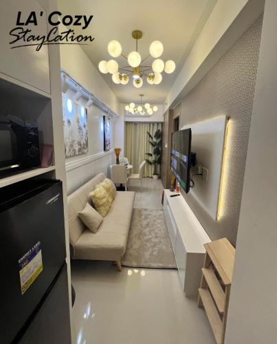 a living room with a couch and a television at Smdc Coast Residences- LA Cozy Staycation in Manila