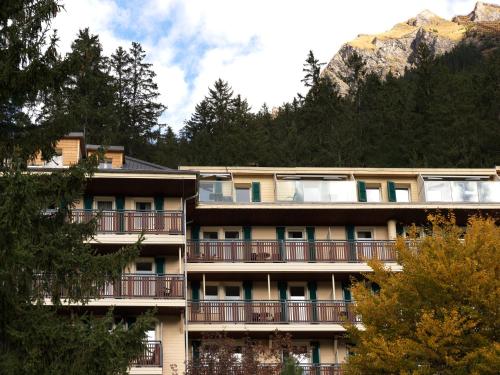 an apartment building with a mountain in the background at Beausite Park Hotel & Spa in Wengen