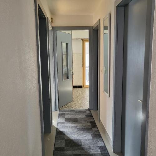 a hallway with two doors and a rug at Appartement Randogne avec grande terrasse in Crans-Montana