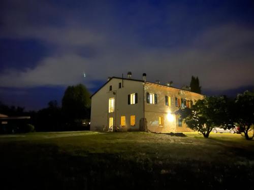 a large white house at night with the lights on at R&B Del Monte in Forlì