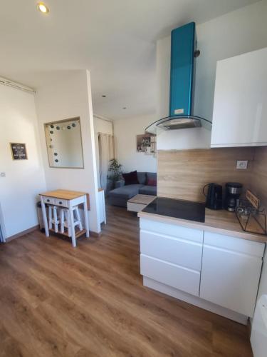 une cuisine et un salon avec un canapé et une table dans l'établissement Appartement lumineux en centre-ville, à Neuves-Maisons