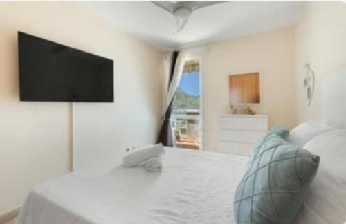 a white bedroom with a flat screen tv on a bed at Gran View Apartment Sea Wiew, WiFi,Garage, Car rental in Adeje