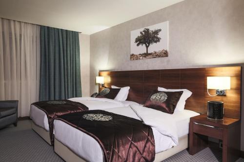 a hotel room with a large bed and a desk at Nevali Hotel & Convention Center in Urfa