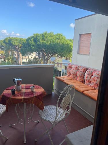 a table and chairs on a balcony with a couch at Grande e luminoso appartamento in Lido di Classe