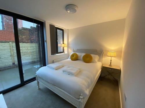 ein Schlafzimmer mit einem Bett mit zwei gelben Kissen darauf in der Unterkunft Ranmoor Serviced Apartments at Wilkinson Lane- The Burlington Suite in Sheffield