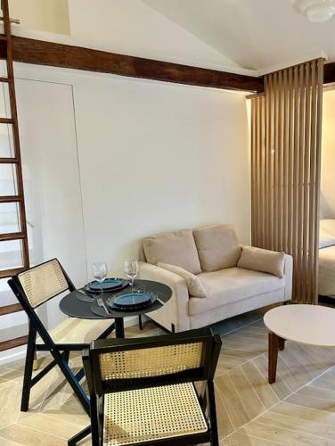 un salon avec un canapé, une table et des chaises dans l'établissement Paris - Marais, à Paris