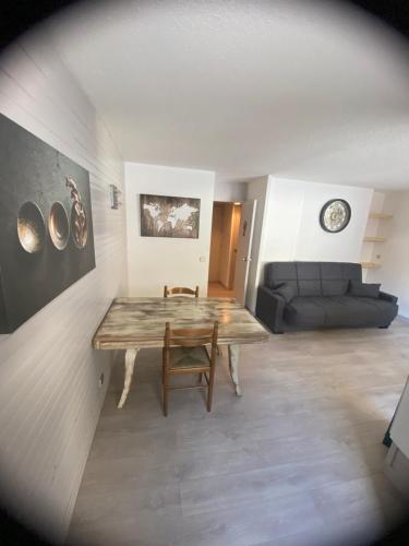 un salon avec une table en bois et un canapé dans l'établissement Charmant appt 2 Ch St Jacques, à La Plagne Tarentaise