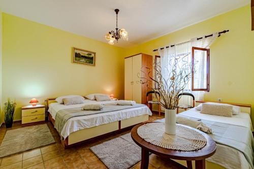 a bedroom with two beds and a table at Holiday Home Gradina, Island of Korčula in Vela Luka