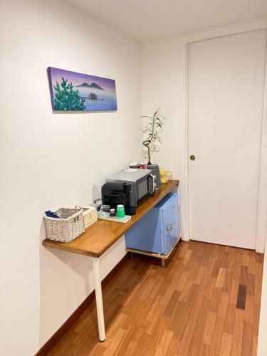 Habitación con mesa y microondas. en Mamà Vesuvius Home, en Portici