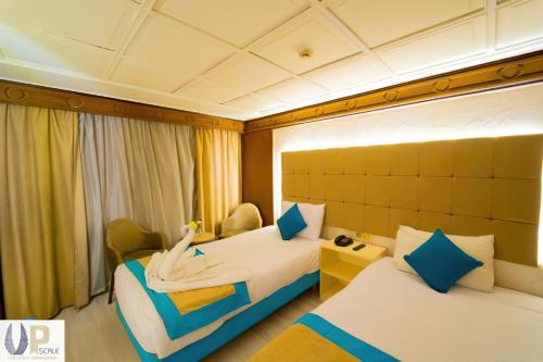 a hotel room with two beds with a woman laying on them at Nile Cruise 2 nights 3 Days From Aswan to Luxor with tours in Aswan