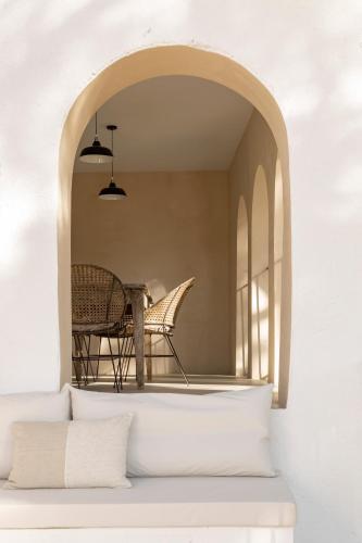 a room with a table and a chair under an archway at Mas Grimosach - Masía en finca y bodega ecológica - Adults Only in Sant Pau dʼOrdal