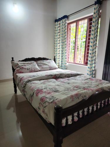 a bed sitting in a bedroom with a window at The Fika Casa Home Stay in Meenangadi