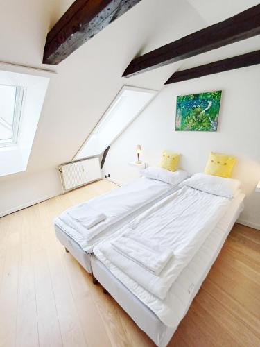 a bedroom with a large bed in a attic at Bright City Central Apartment with Balcony in Randers