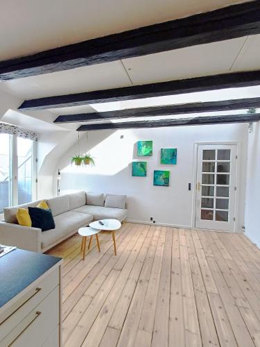 a living room with a couch and a table at Bright City Central Apartment with Balcony in Randers