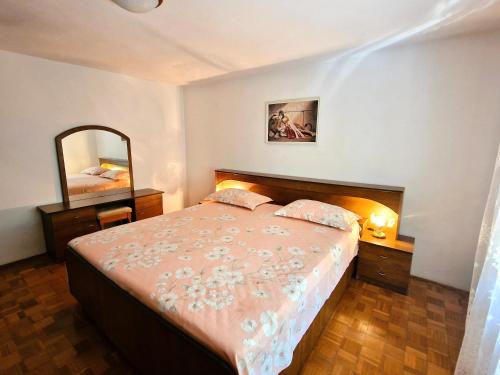 a bedroom with a large bed and a mirror at Apartments Elena in Ugljan