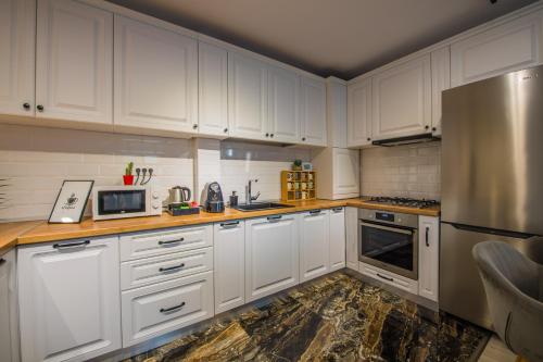 a kitchen with white cabinets and a refrigerator at Alvera Apartament in Alba Iulia