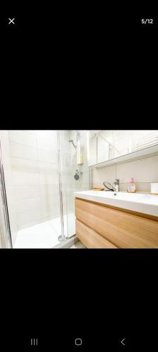 La salle de bains est pourvue d'une douche et d'un lavabo blanc. dans l'établissement Joli appartement centre de Nice, à Nice