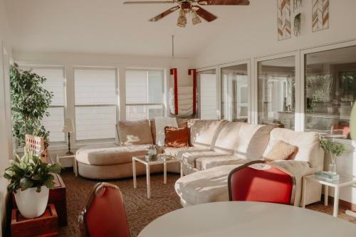 a living room with white furniture and red chairs at Sonlit Retreats in Skyline