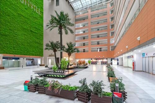a large lobby with palm trees and a building at Apart - Highvill, Хайвилл in Promyshlennyy