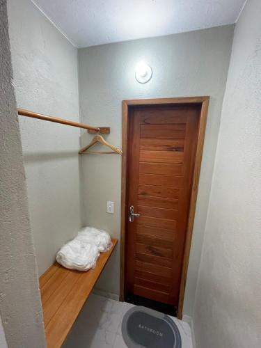 a small room with a wooden door and a closet at Suítes Paraíso Perfeito in Flecheiras