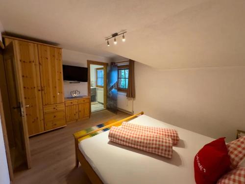 a bedroom with a white bed with red pillows at Apart Eberharter in Aschau
