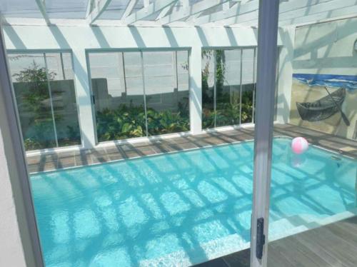 a swimming pool viewed through a window at Paradise in Plettenberg Bay in Plettenberg Bay