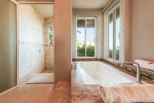 a large bathroom with a large tub and a window at Casa de las Olas - Villa Ocean View in San José del Cabo