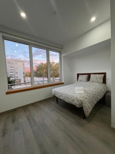 a bedroom with a bed and a large window at Fátima Serenity Apartments in Fátima