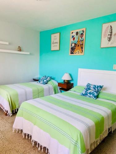 two beds in a room with blue walls at CASA JOAQUÍN HOSTAL in Oaxaca City