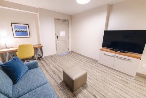 a living room with a couch and a flat screen tv at Hilton Garden Inn Lakewood in Lakewood