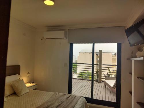 een slaapkamer met een bed en uitzicht op een balkon bij 3 Personas - Balcon, Wifi & Cafe in Santiago del Estero