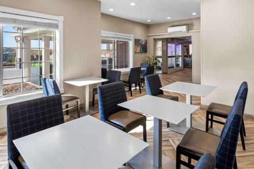 a restaurant with tables and chairs and windows at Best Western Worlds Of Fun in Kansas City