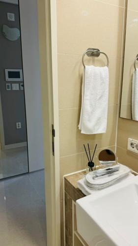 a bathroom with a sink and a mirror and a towel at Apart - Highvill, Хайвилл in Promyshlennyy