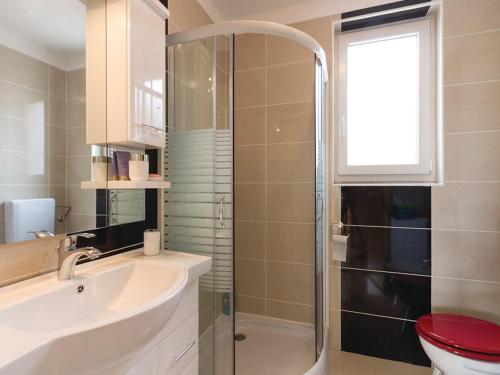 een badkamer met een douche, een wastafel en een toilet bij Villa Patricia in Štinjan