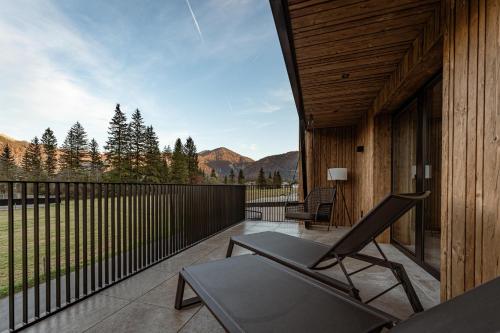 a deck with a chair and a table on a balcony at Jaggling Appartements in Sankt Ulrich am Pillersee