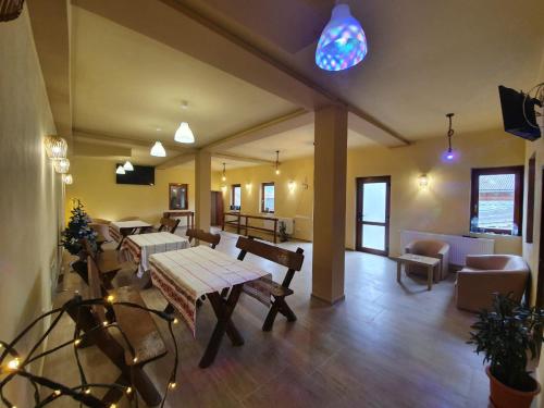 a large living room with a table and chairs at PENSIUNEA LEIA Transfăgărășan in Cîrţişoara