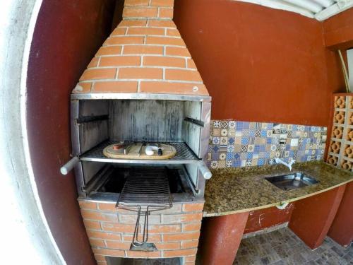a kitchen with a brick oven in a room at Refúgio da Ilha in Ilha Comprida