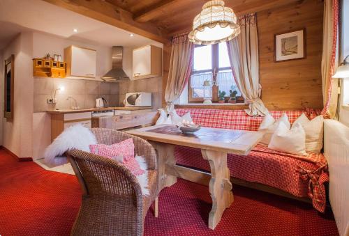 a living room with a table and a kitchen at Das Landhaus in Pfronten