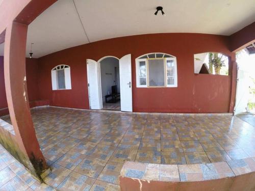 an empty room with red walls and a tile floor at Refúgio da Ilha in Ilha Comprida