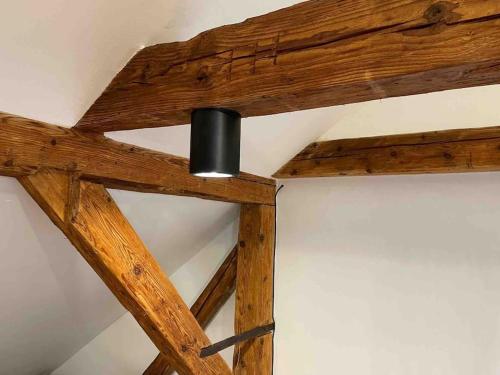 a light on the ceiling of a room with wooden beams at Vila 100klasa in Nejdek