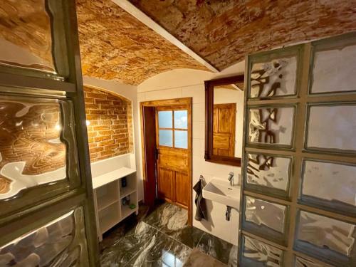 a bathroom with a door and a brick wall at Vila 100klasa in Nejdek